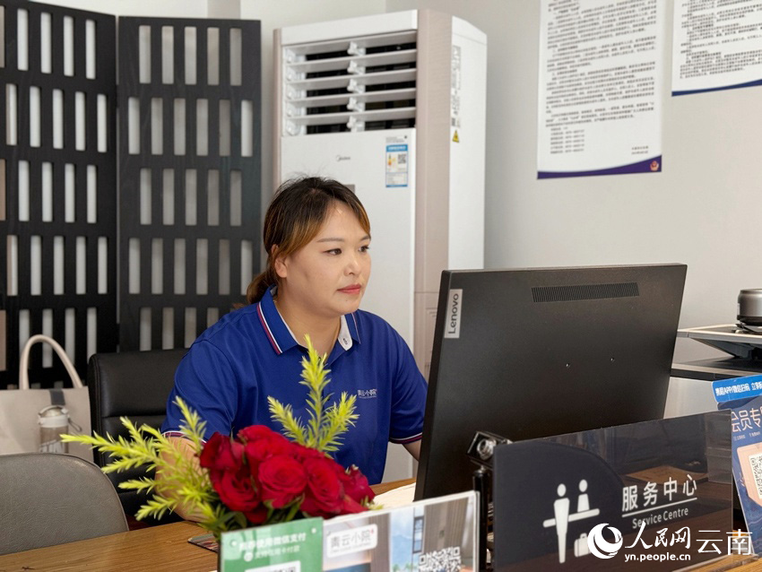 杨节正在帮游客办理入住。人民网记者-蔡树菁摄